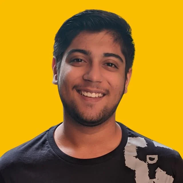 Hardik Dewra, smiling, in a black t-shirt against a yellow background